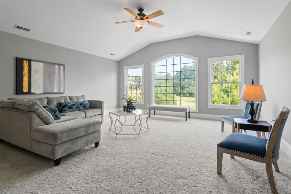 Clean, well-maintained carpeted living room with natural light