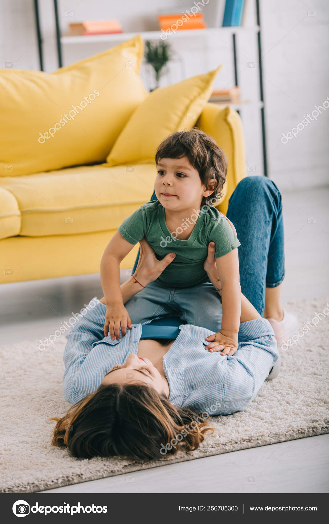 Mother and young child playing together on carpet